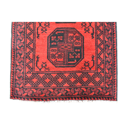 Fringe-end detail of Afghan Turkoman runner showing a dark octagonal gul, red geometric borders and ivory fringe