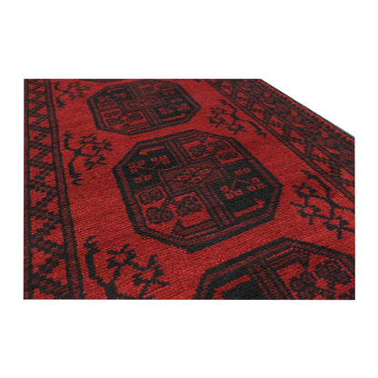 Angled field detail of Afghan Turkoman runner rug with red and dark geometric motifs, 280 x 79 cm