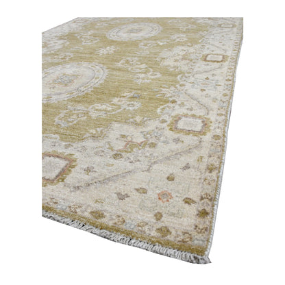 Angled view of Afghan Ziegler rug showing its olive-beige pile, pale floral border and short ivory fringe