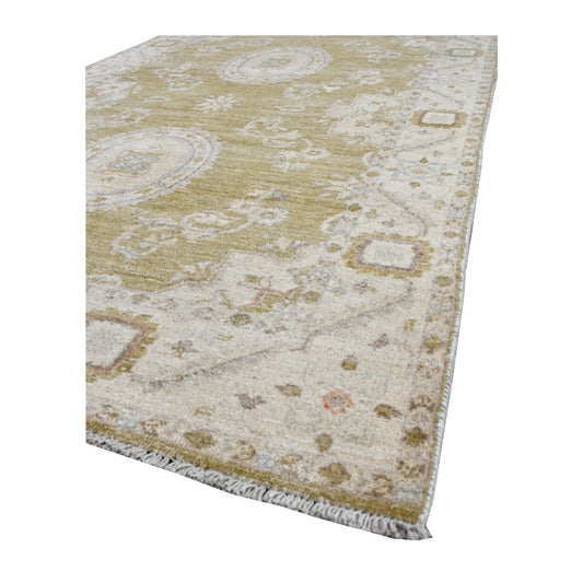 Angled view of Afghan Ziegler rug showing its olive-beige pile, pale floral border and short ivory fringe