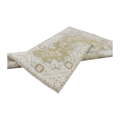Folded view of Afghan Ziegler hand-knotted wool rug showing its twin-medallion design, pale border and fringe