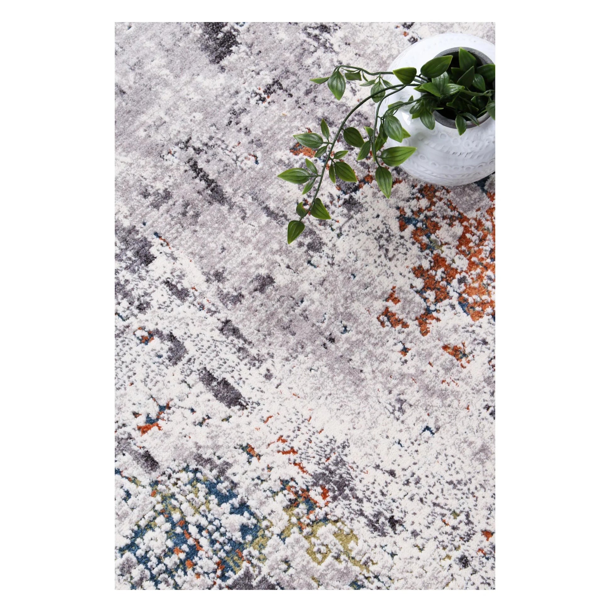 Styled close-up of Almeras A4 grey abstract rug with rust and blue-green accents