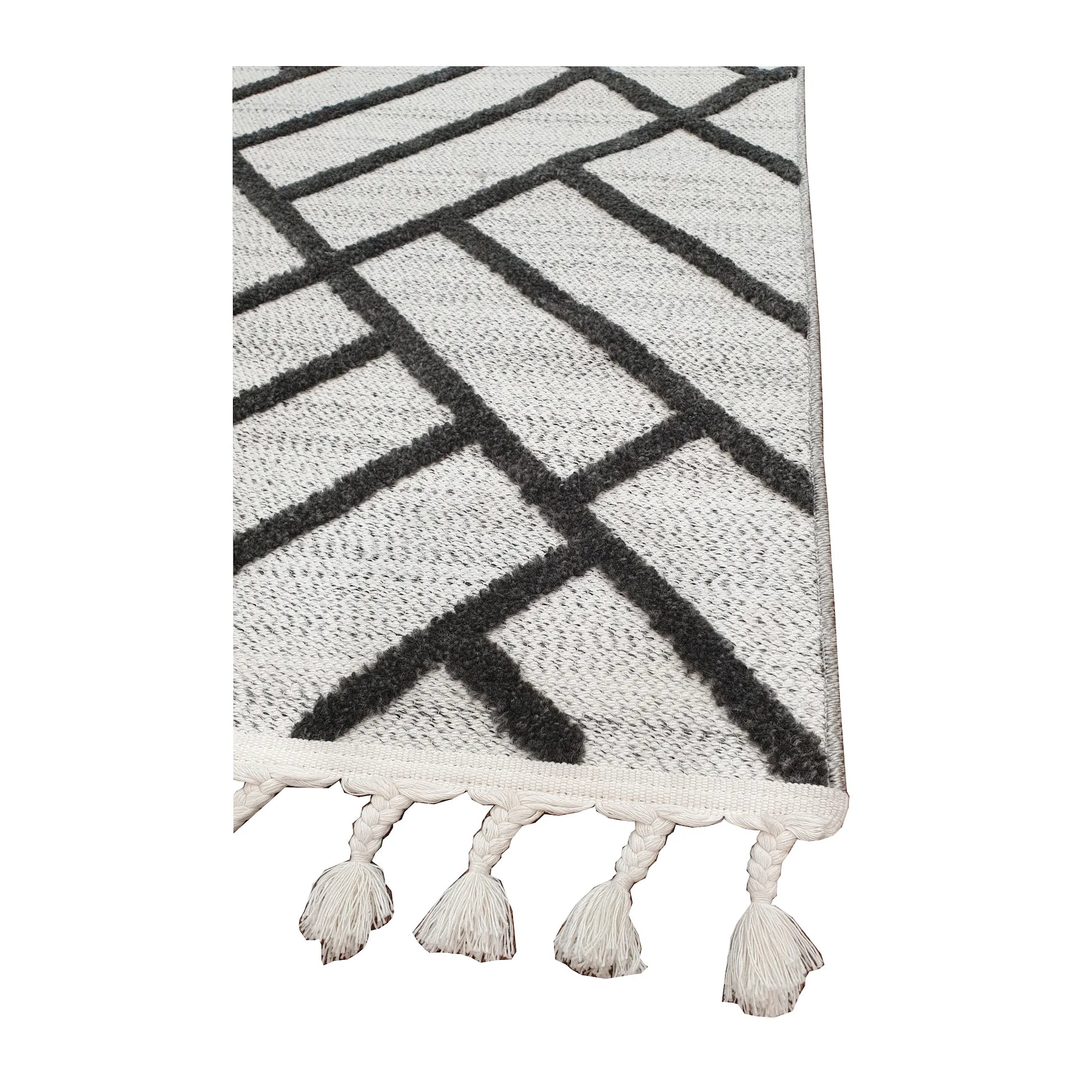 Tassel edge detail of Archer runner rug showing ivory textured surface and black geometric design