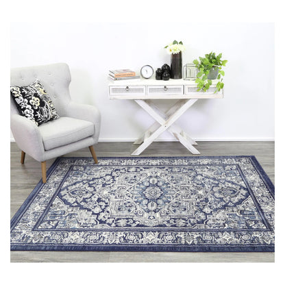 Arya navy rosette traditional rug styled with white furniture in a neutral setting