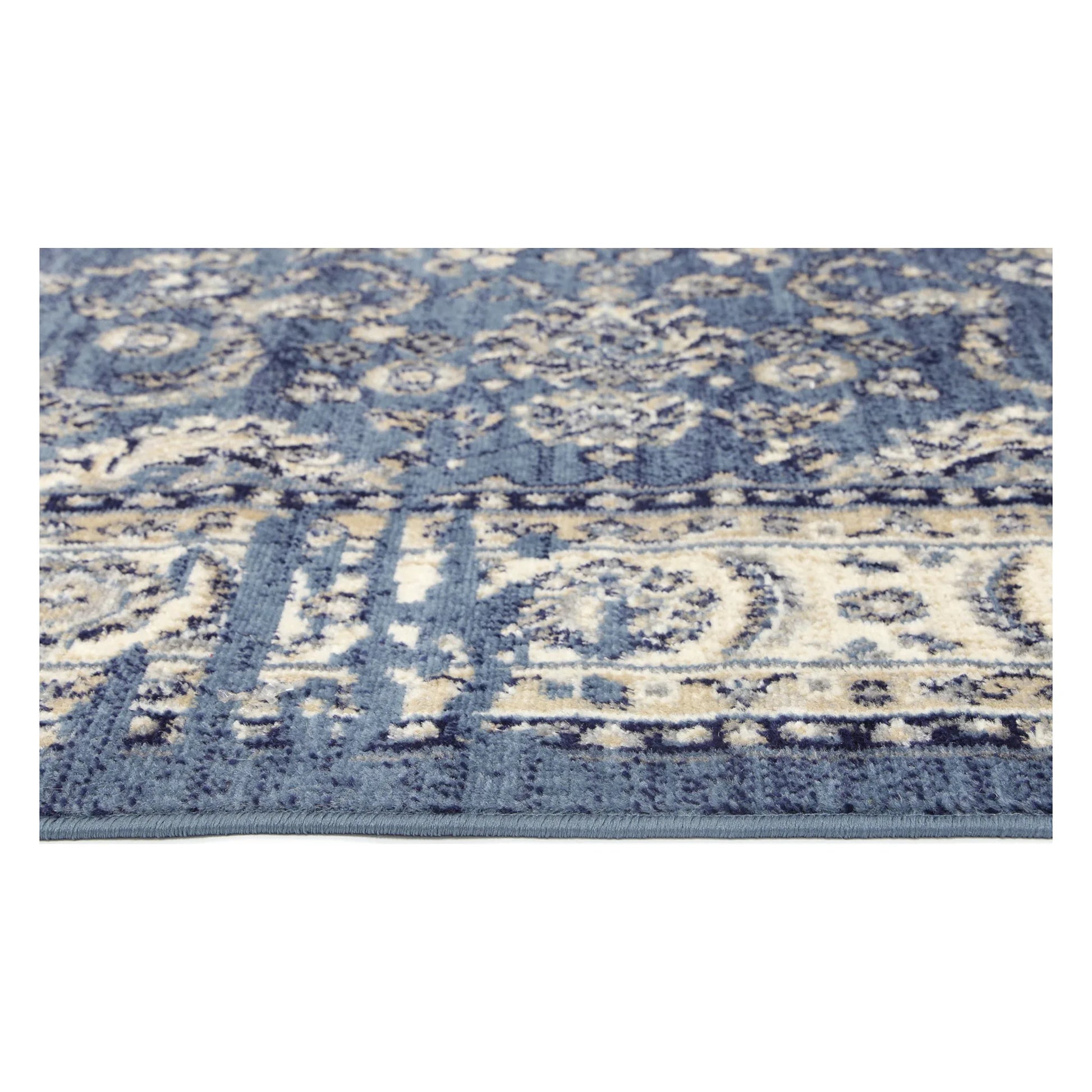 Border texture detail of Arya blue traditional rug showing ivory floral pattern