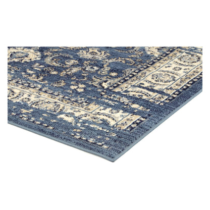 Corner detail of Arya blue traditional floral rug showing bound edge and pile texture