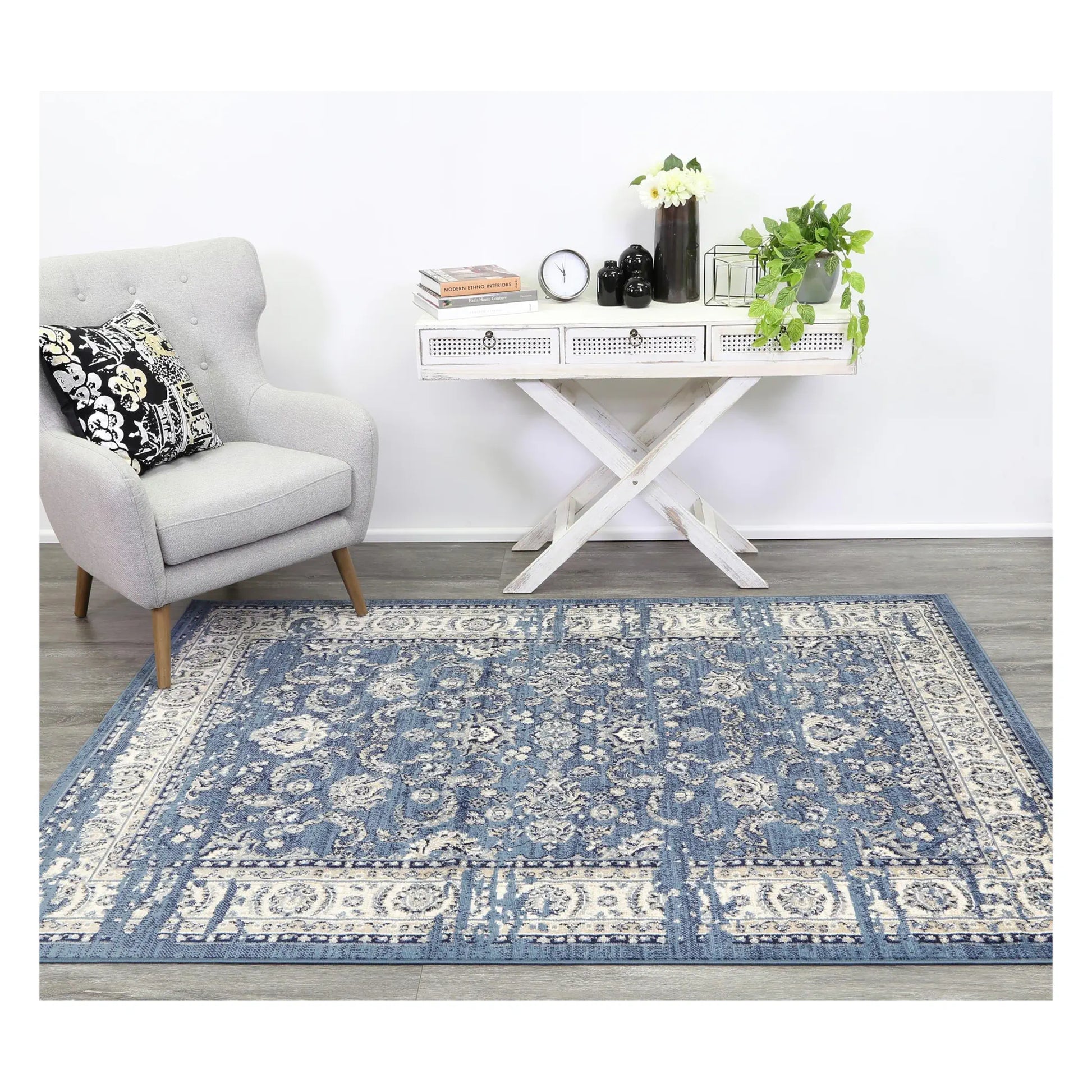 Arya blue traditional floral rug styled with white furniture in a neutral setting