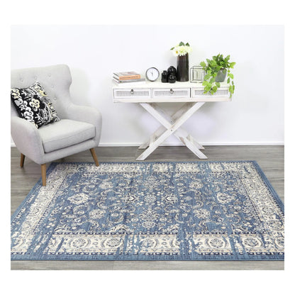 Arya blue traditional floral rug styled with white furniture in a neutral setting