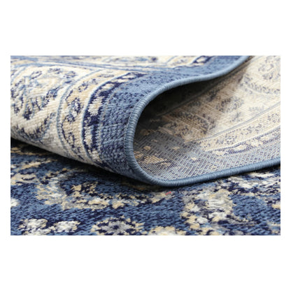 Rolled corner detail of Arya blue traditional floral rug showing flexible edge and texture