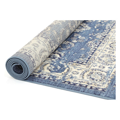Rolled view of Arya blue traditional floral rug showing surface pattern and backing