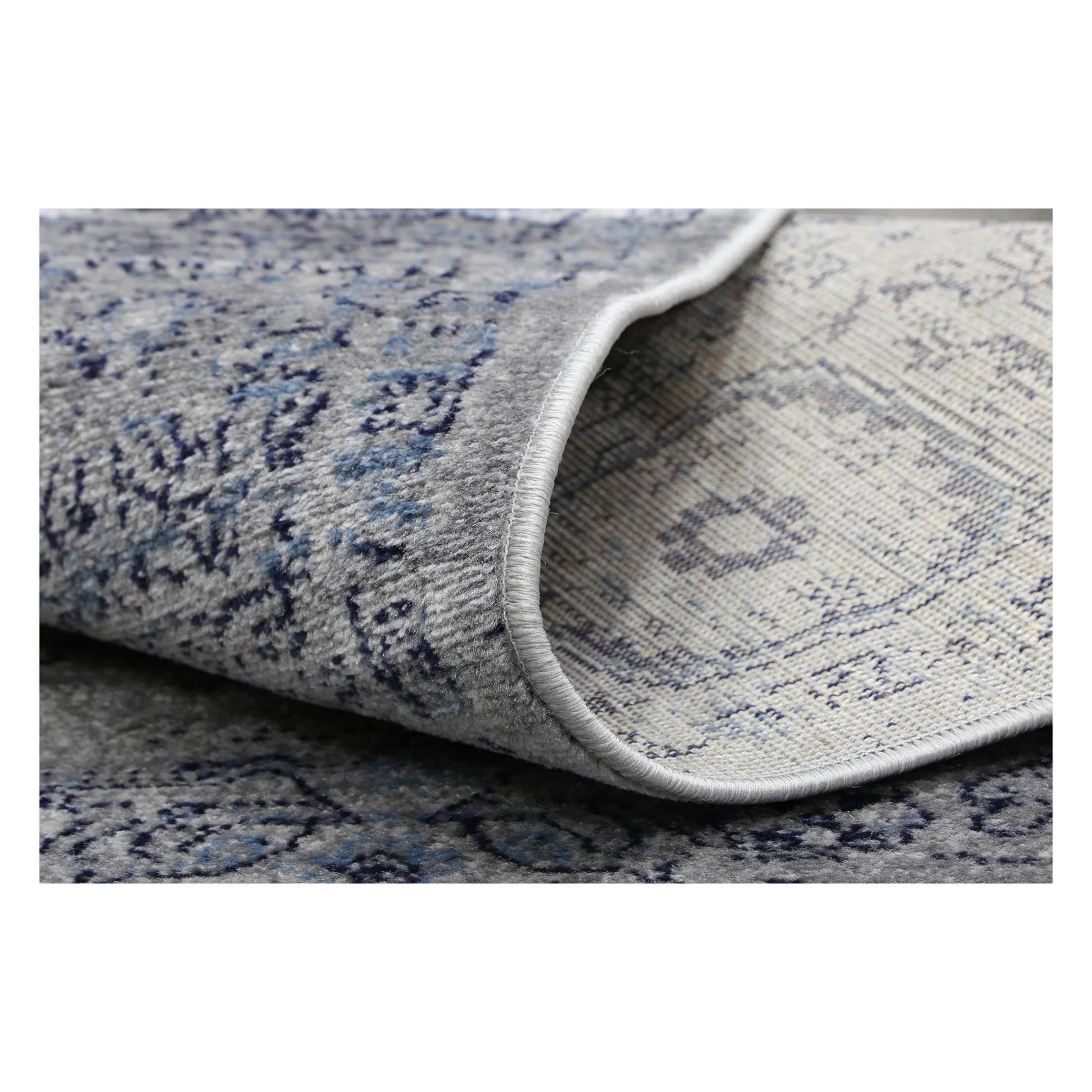 Rolled corner detail of Arya charcoal traditional rug showing flexible edge and texture