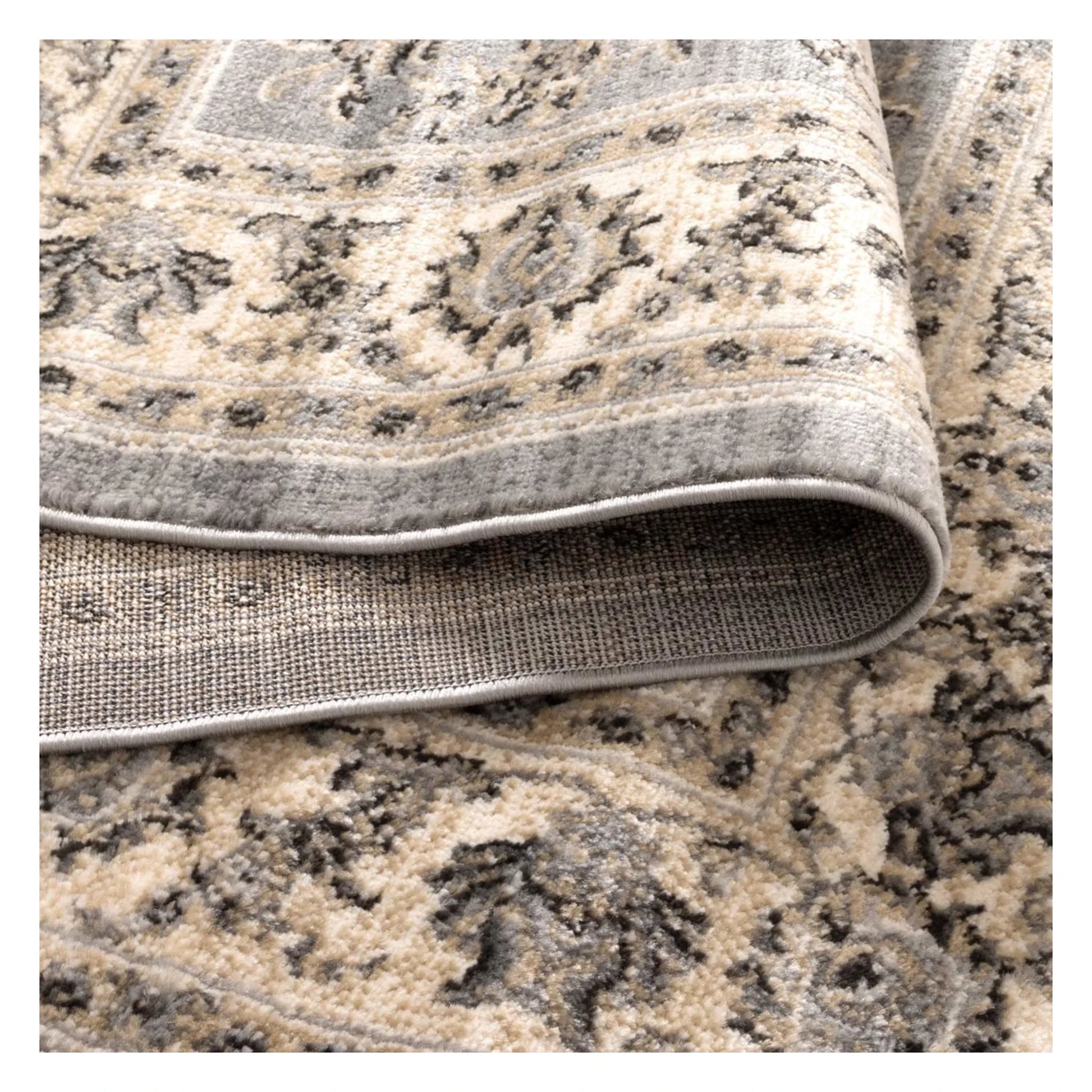 Folded edge detail of Arya grey traditional floral rug showing soft pile texture