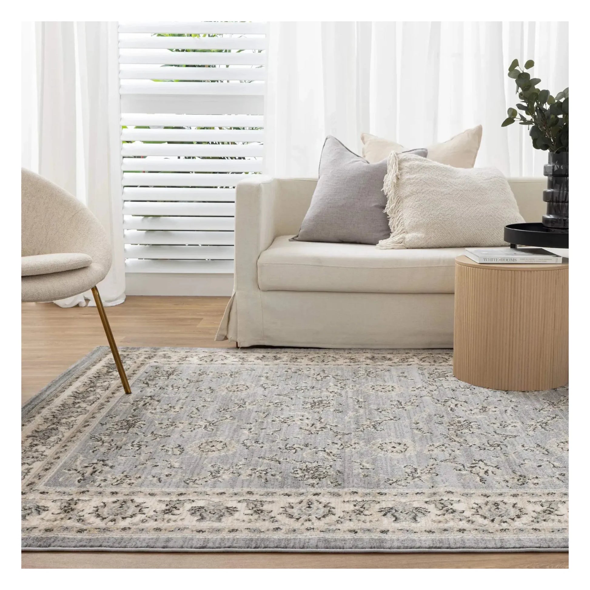 Arya grey traditional floral rug styled in a light neutral interior setting