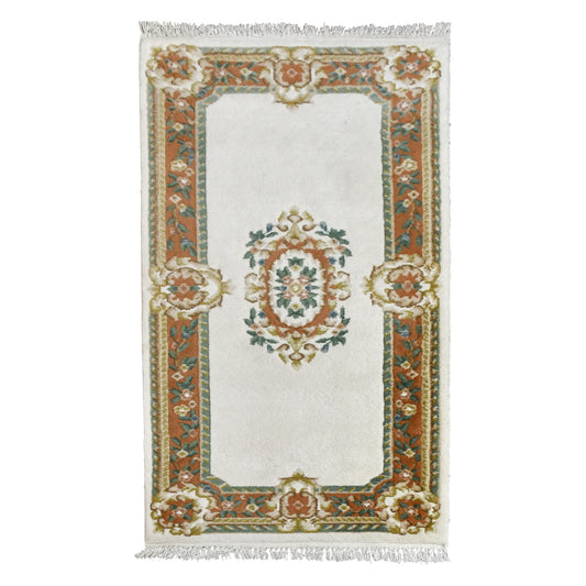 Full view of Aubusson hand-knotted wool rug with ivory field, oval floral medallion and ornate border, 180 x 92 cm