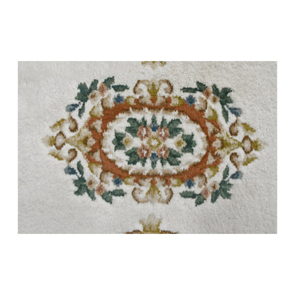 Central medallion detail of Aubusson rug with terracotta, muted green and dusty rose floral motifs