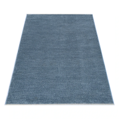 Angled full view of Baltimore Chobi Ocean grey rug showing the plain textured field