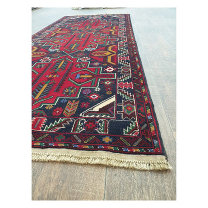 Angled detail of Baluchi runner rug showing border pattern, fringe, and hand-knotted texture, 200 x 83 cm
