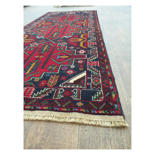 Angled detail of Baluchi runner rug showing border pattern, fringe, and hand-knotted texture, 200 x 83 cm