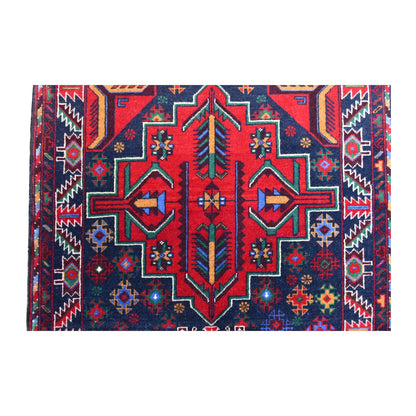 Close-up of Baluchi runner showing a large red central medallion with teal, ivory and dark geometric outlines