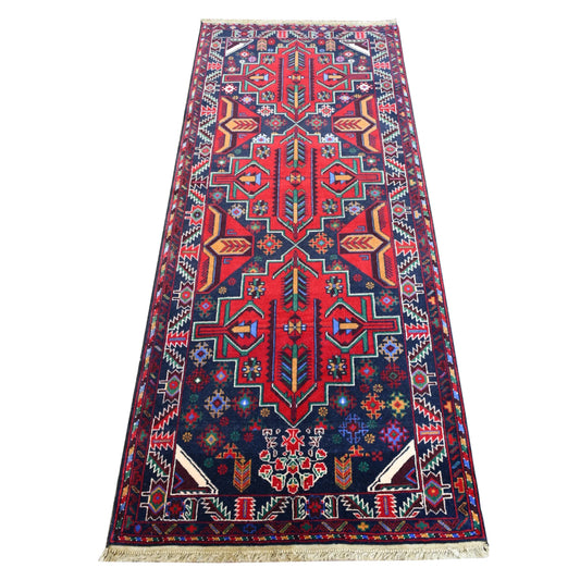 Full view of Baluchi hand-knotted runner rug with bold red geometric medallions on a deep navy field, 200 x 83 cm