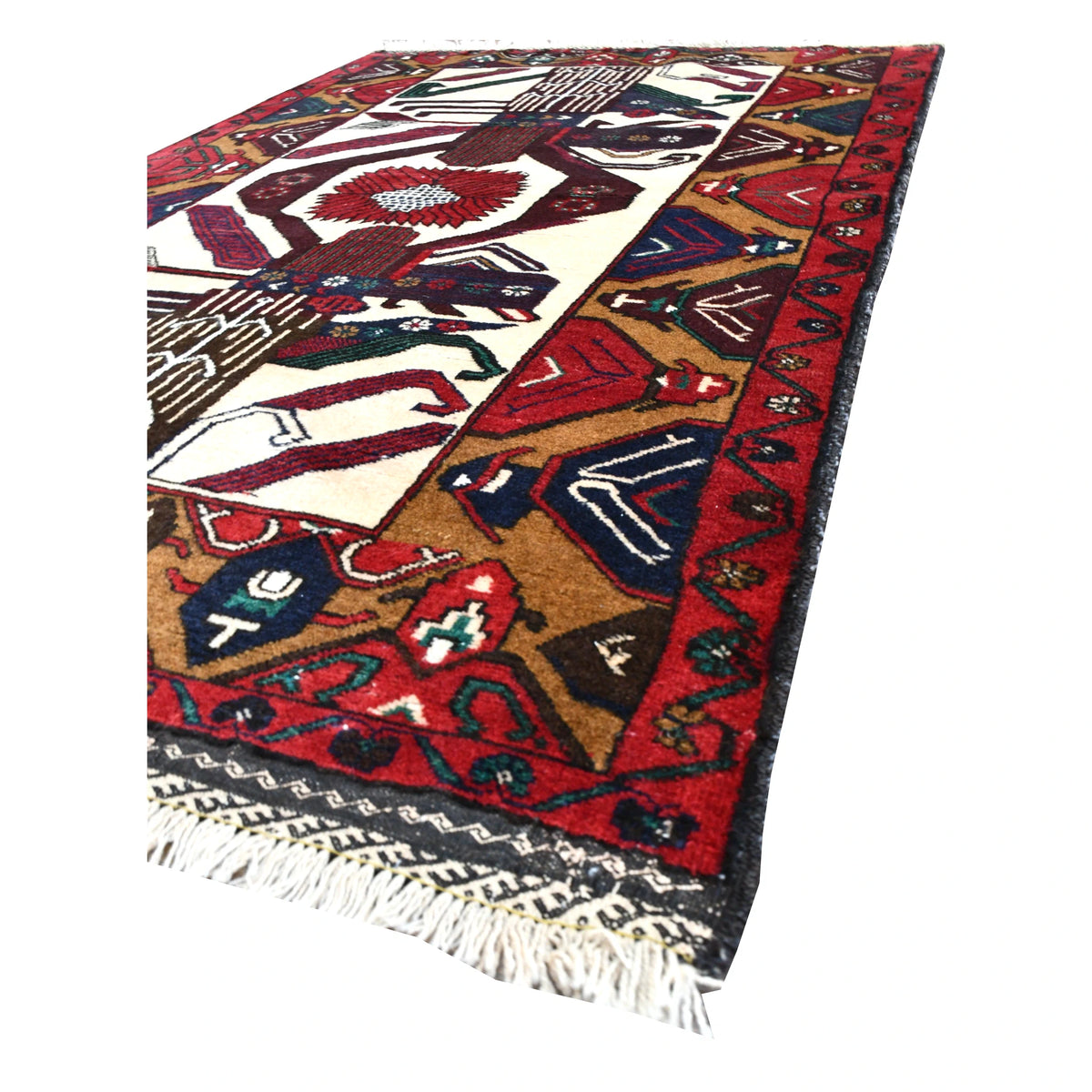 Angled view of Baluchi hand-knotted wool rug showing its patterned field, deep red border and pale fringe