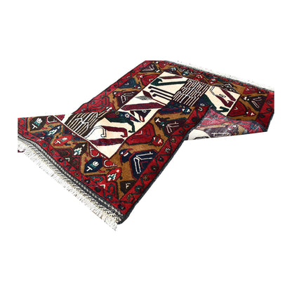 Folded view of Baluchi hand-knotted wool rug showing its patterned pile, border and fringe