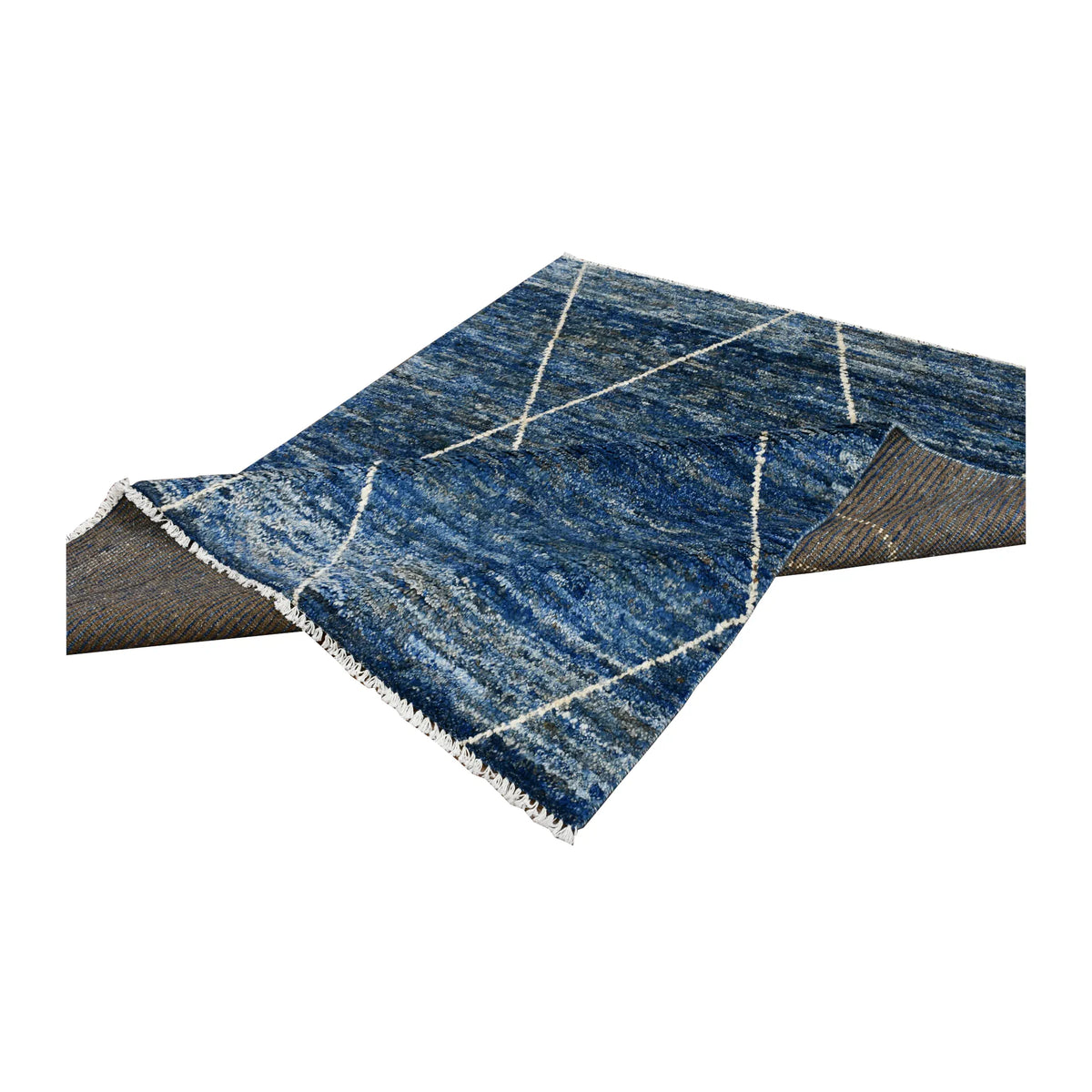 Folded view of Moroccan wool rug showing the blue patterned pile, brown-toned reverse weave and pale fringe