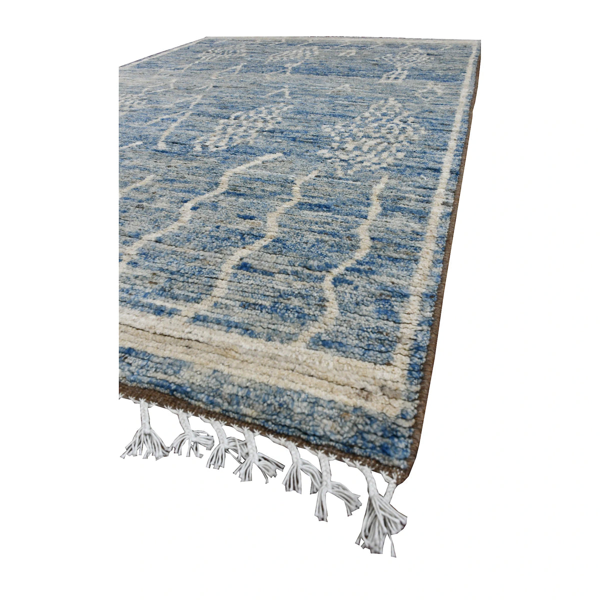 Angled view of the blue Moroccan wool rug showing tonal colour variation, raised ivory motifs and fringe