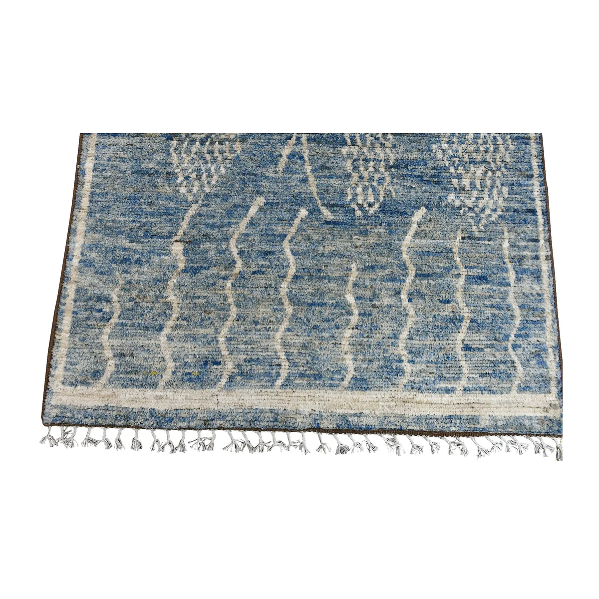 Fringed-end and field detail of the blue Moroccan wool rug with raised ivory abstract motifs