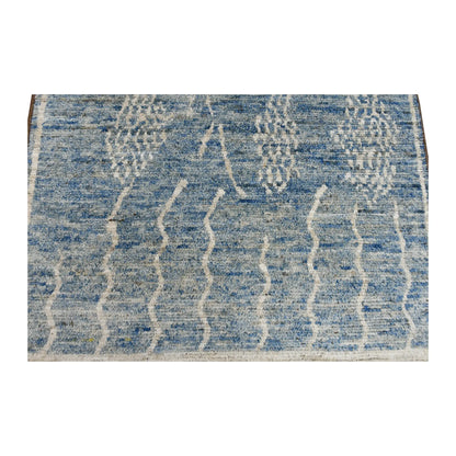 Pattern detail of the tonal blue field with raised ivory abstract motifs and pale border