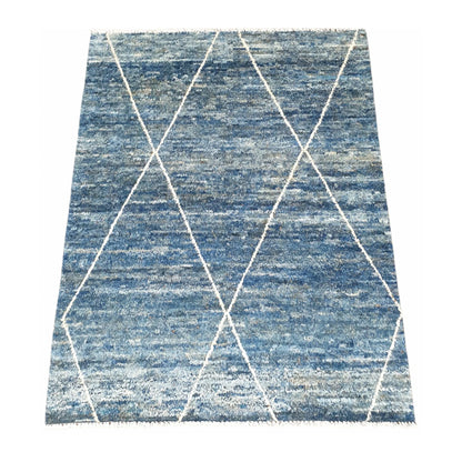 Angled view of blue Moroccan wool rug with open ivory diamond pattern, 180 x 140 cm