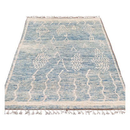 Full view of blue Moroccan wool rug with raised ivory motifs, 240 x 156 cm
