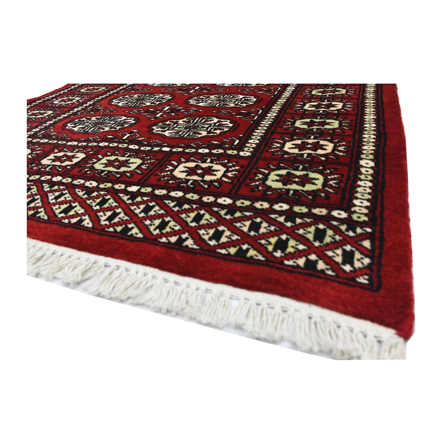 Angled corner and fringe view of Bokhara wool rug showing red field, geometric border and ivory fringe