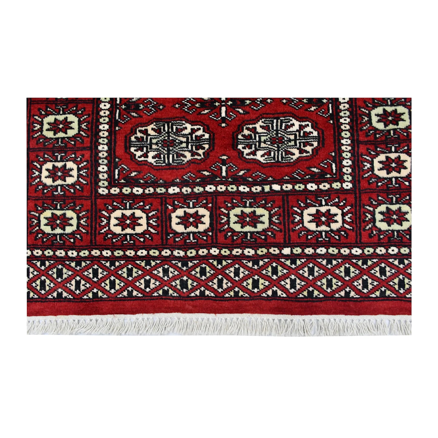 End field, border and fringe detail of Bokhara hand-knotted wool rug showing red pile, oval motifs and patterned border
