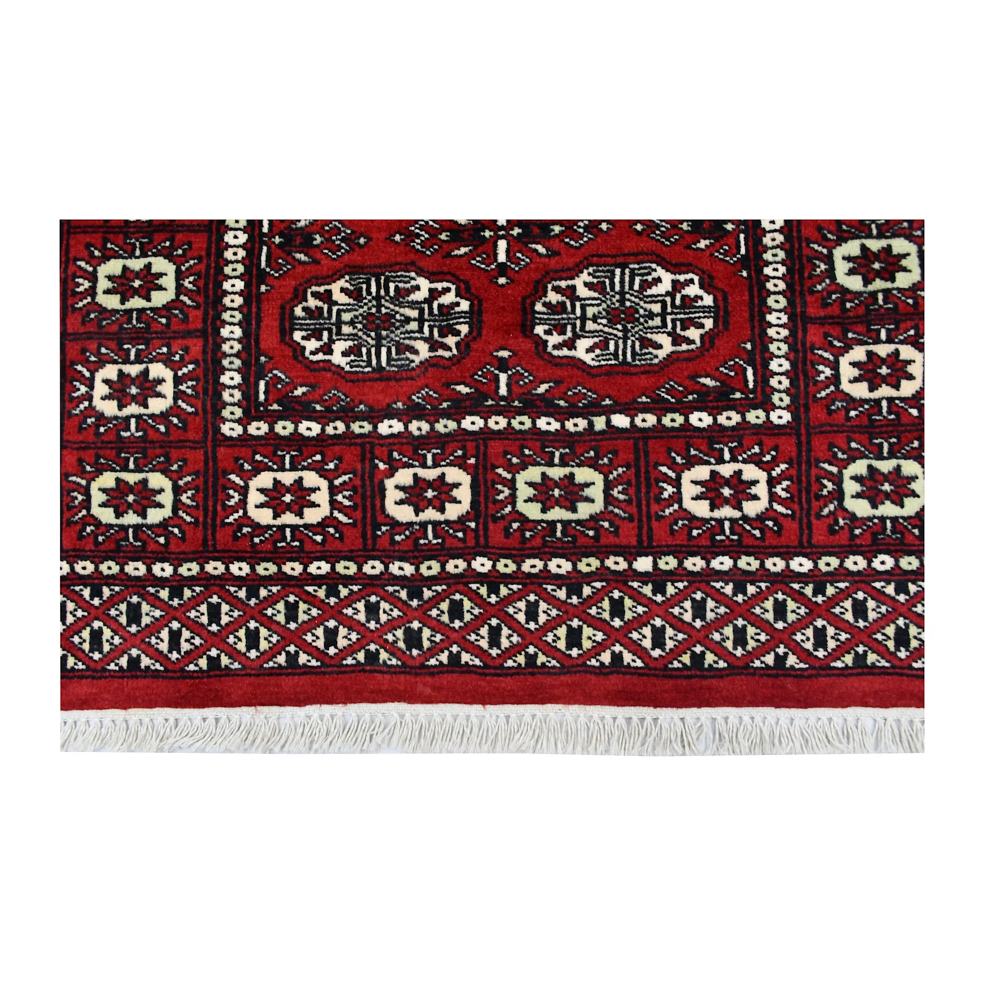 End field, border and fringe detail of Bokhara hand-knotted wool rug showing red pile, oval motifs and patterned border