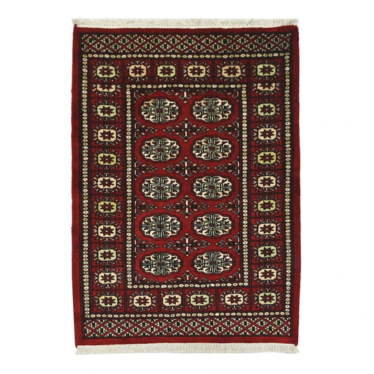 Full view of Bokhara hand-knotted wool rug with red field and repeated oval gul-style motifs, 115 x 82 cm