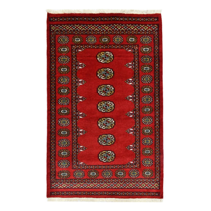 Full view of Bokhara hand-knotted wool rug with red field and repeated oval gul-style motifs, 158 x 93 cm