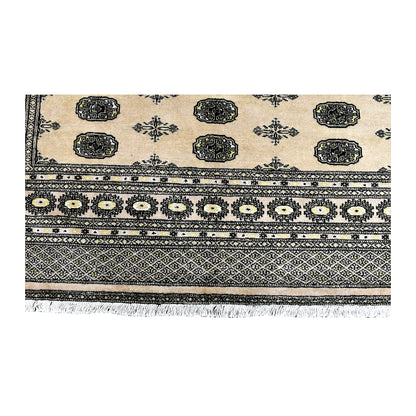 Fringe-end detail of Bokhara rug showing oval guls, a rosette band, diamond-lattice borders and white fringe