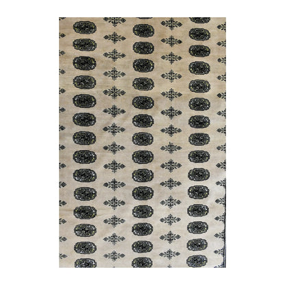 Field detail of Bokhara wool rug showing aligned oval guls separated by smaller cross-shaped motifs on warm ivory