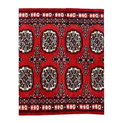 End field and border detail of Bokhara hand-knotted wool runner rug showing red pile, black outlines and ivory accents