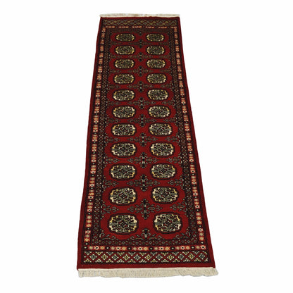 Full view of Bokhara hand-knotted wool runner rug with red field and repeated oval gul-style motifs, 191 x 63 cm