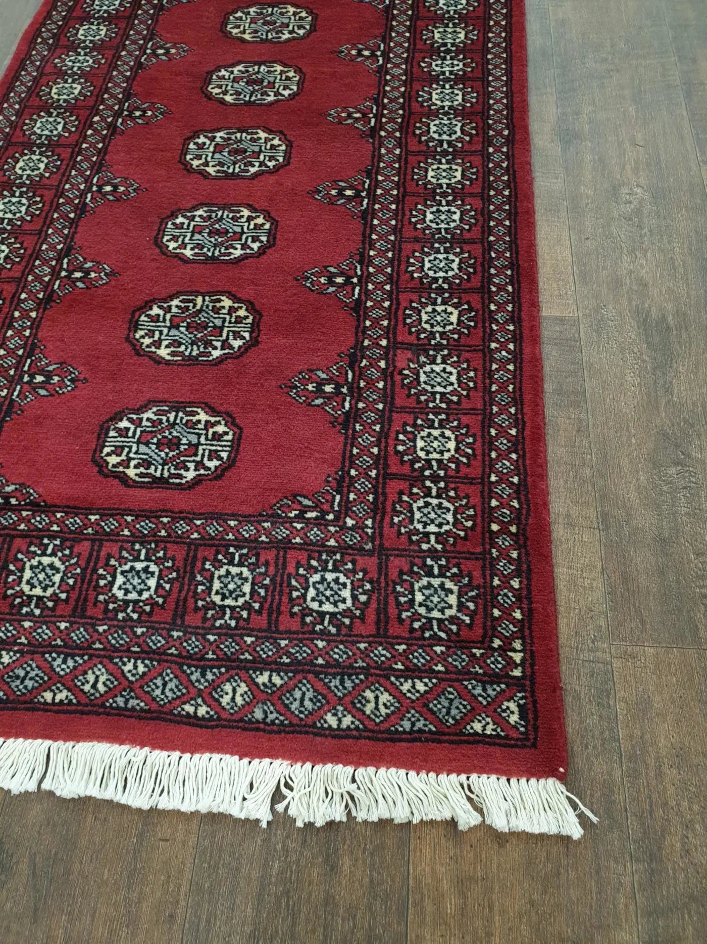 Bokhara hand-knotted wool runner rug 249 x 77 cm end border and fringe detail