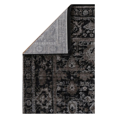 Folded corner of the Brooklyn 300 pewter rug showing the patterned pile, bound edge and woven backing