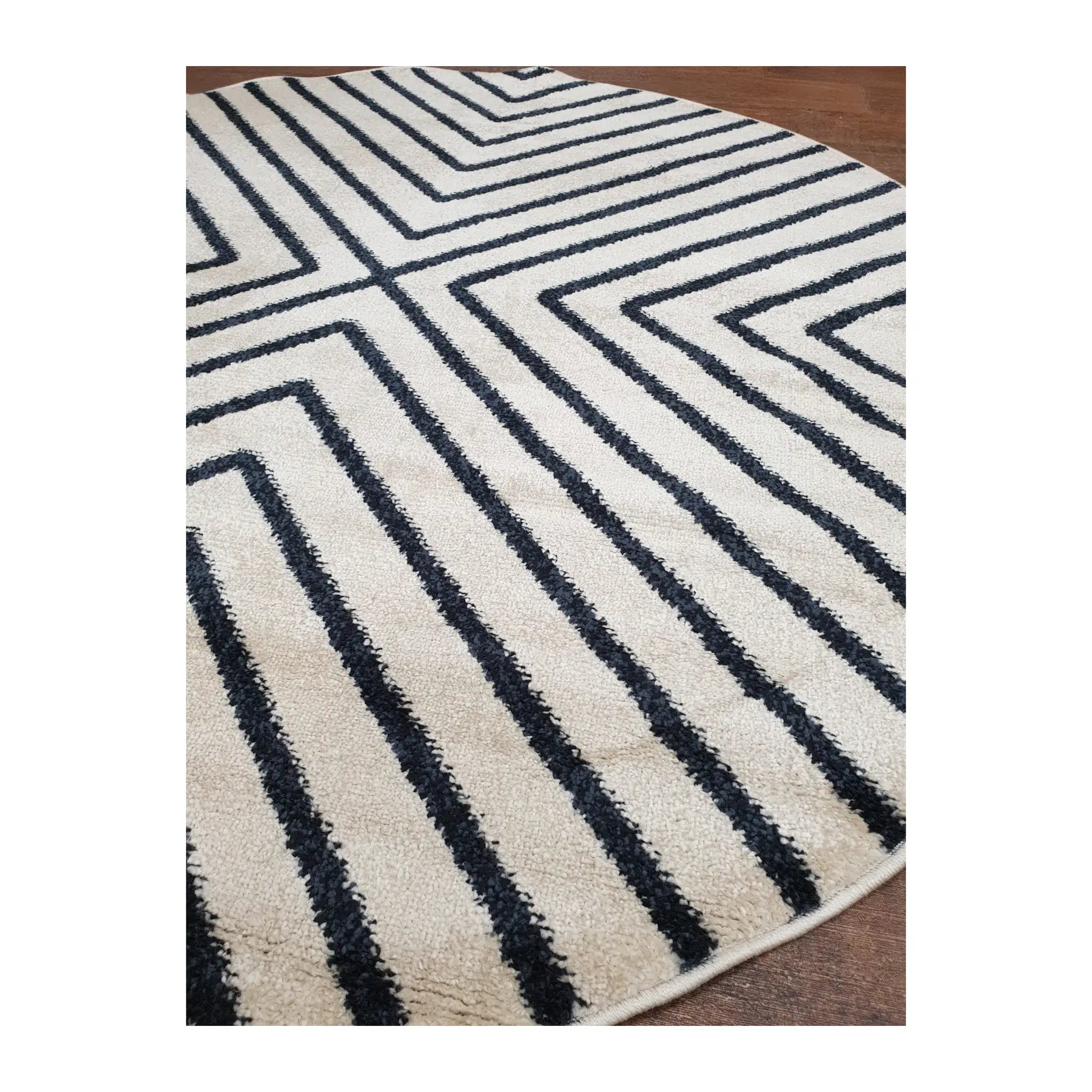 Angled detail of charcoal round rug showing geometric line pattern and edge finish, 160 cm