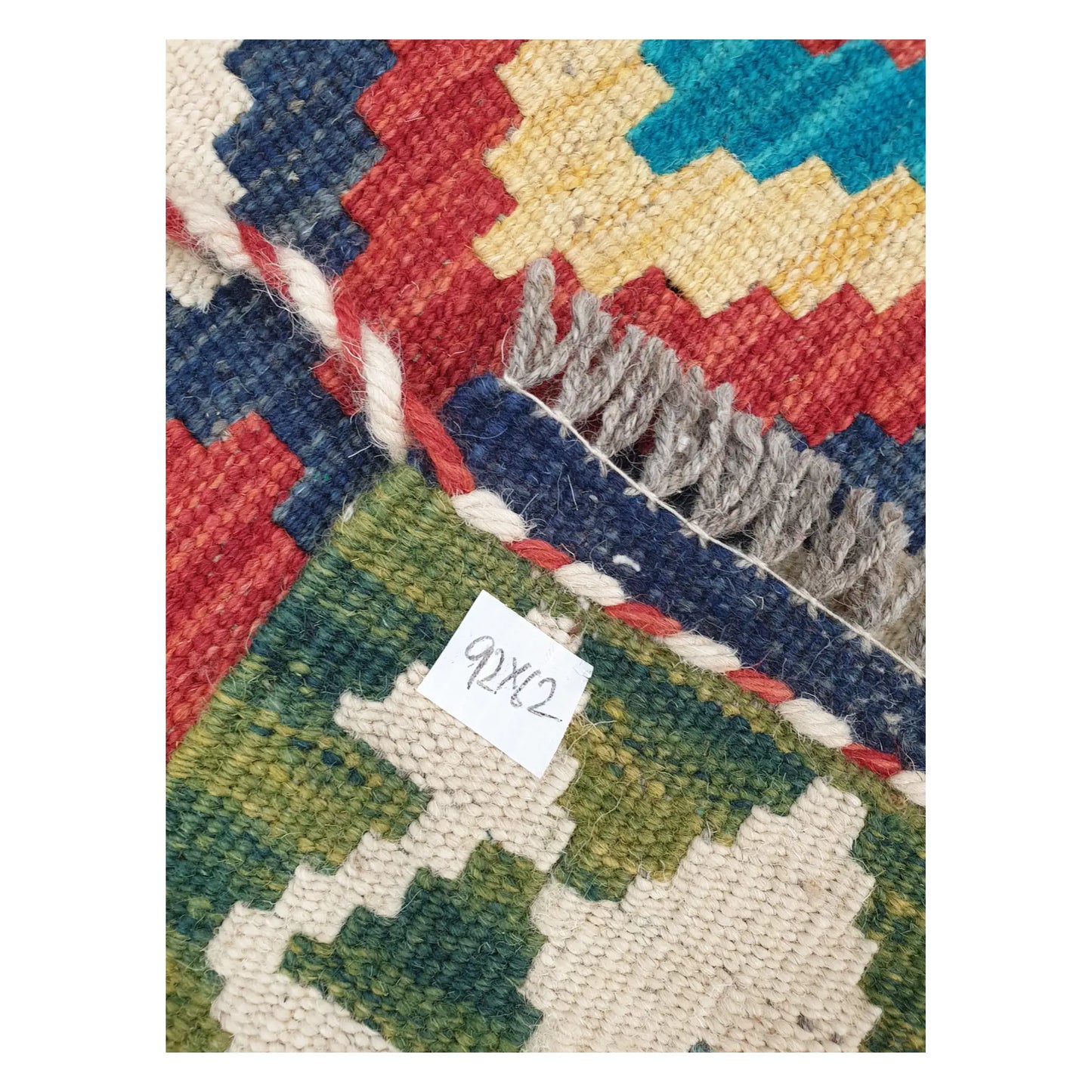 Close-up of Chobi Kilim rug texture, fringe, and multicolour geometric detail, 92 x 62 cm