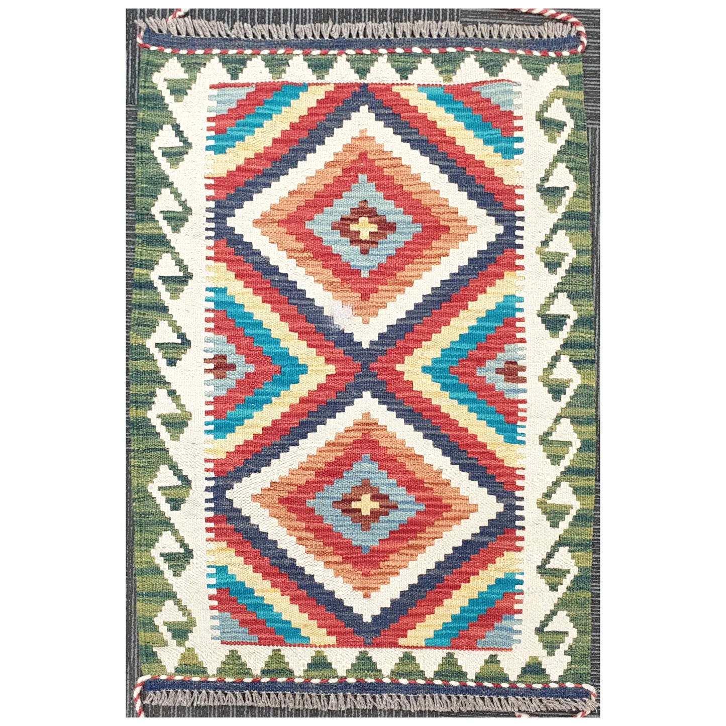 Full view of Chobi Kilim rug with stepped diamond geometric pattern in ivory, blue, red, and green, 92 x 62 cm