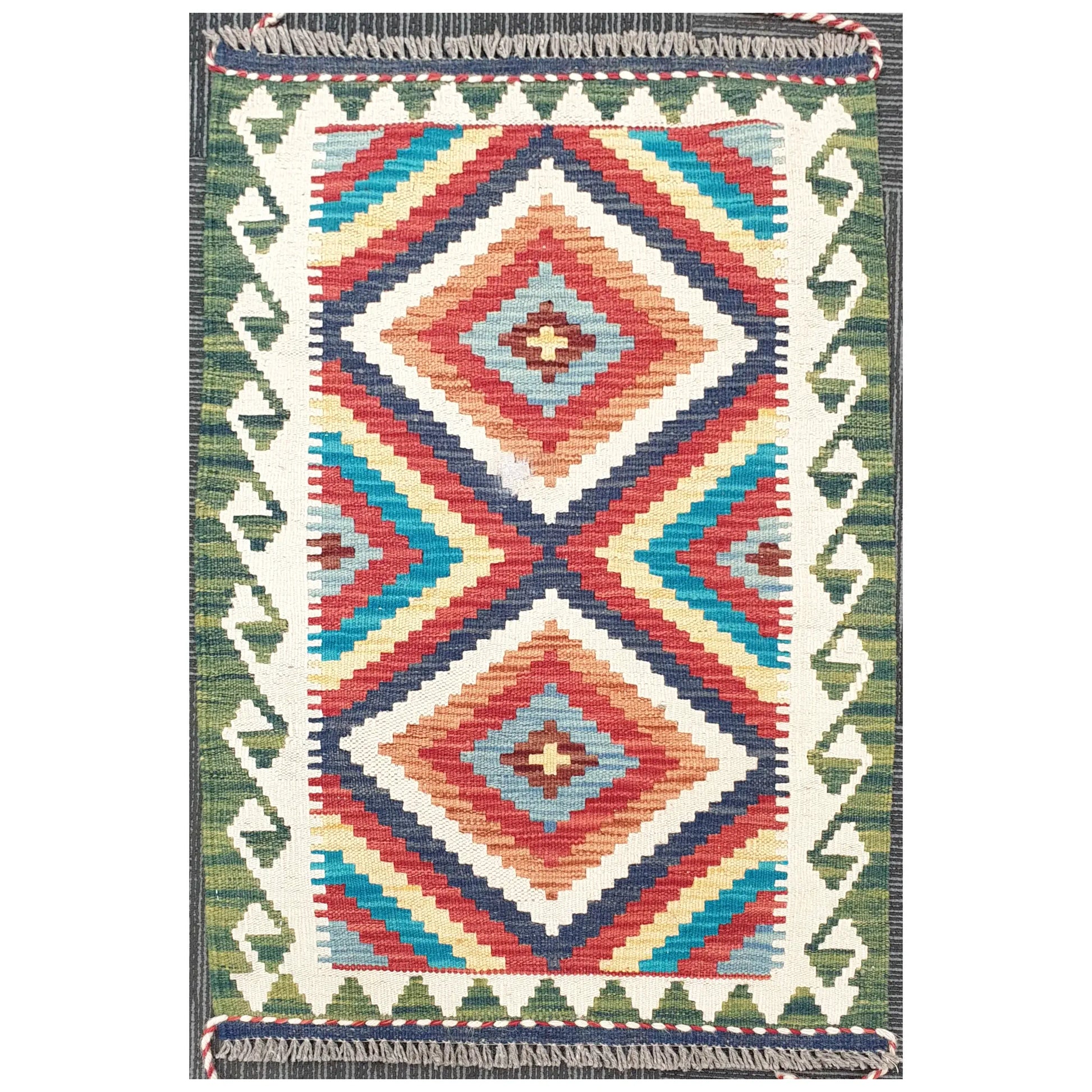 Full view of Chobi Kilim rug with stepped diamond geometric pattern in ivory, blue, red, and green, 92 x 62 cm