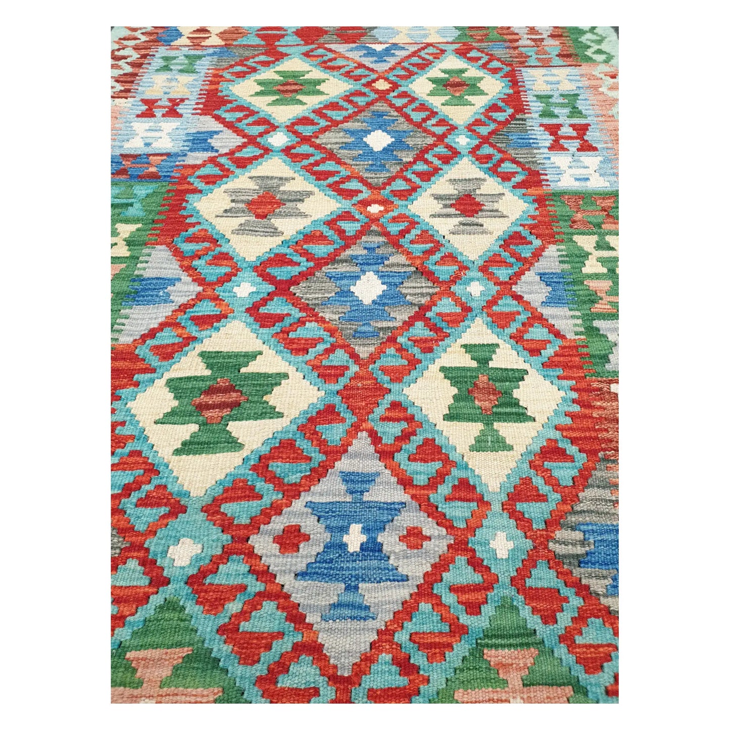 Close-up of Chobi Kilim rug with coral lattice, blue diamond medallions, and green geometric motifs, 156 x 106 cm