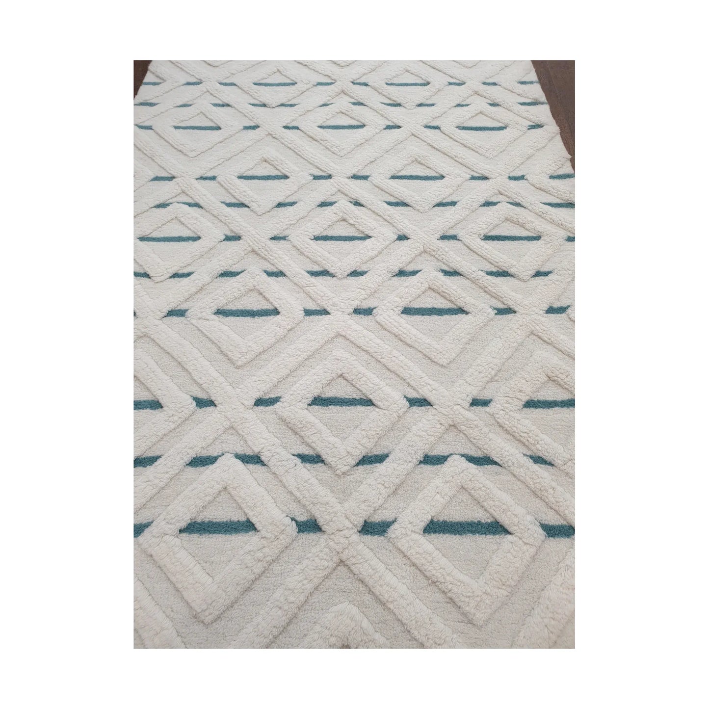 Close-up of cream blue geometric wool rug showing raised pattern and pile detail