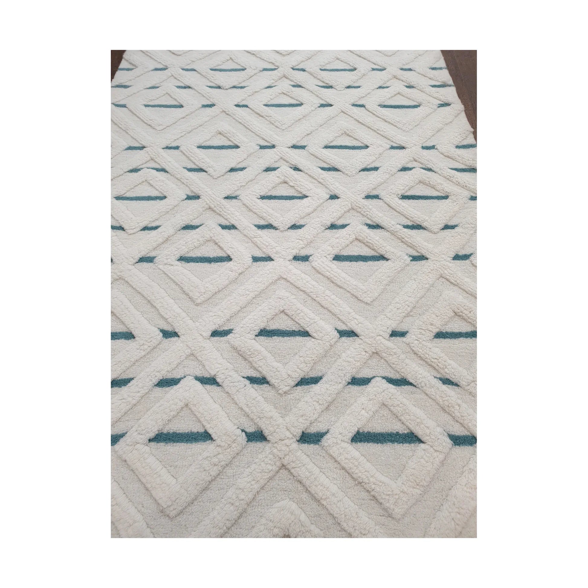 Close-up of cream blue geometric wool rug showing raised pattern and pile detail